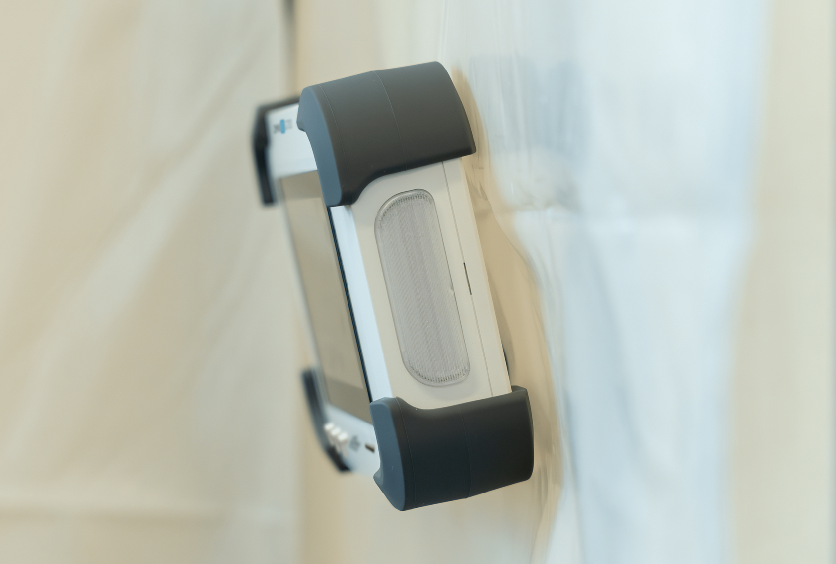 Omni IQ differential pressure monitor hanging on plastic sheeting wall of containment space